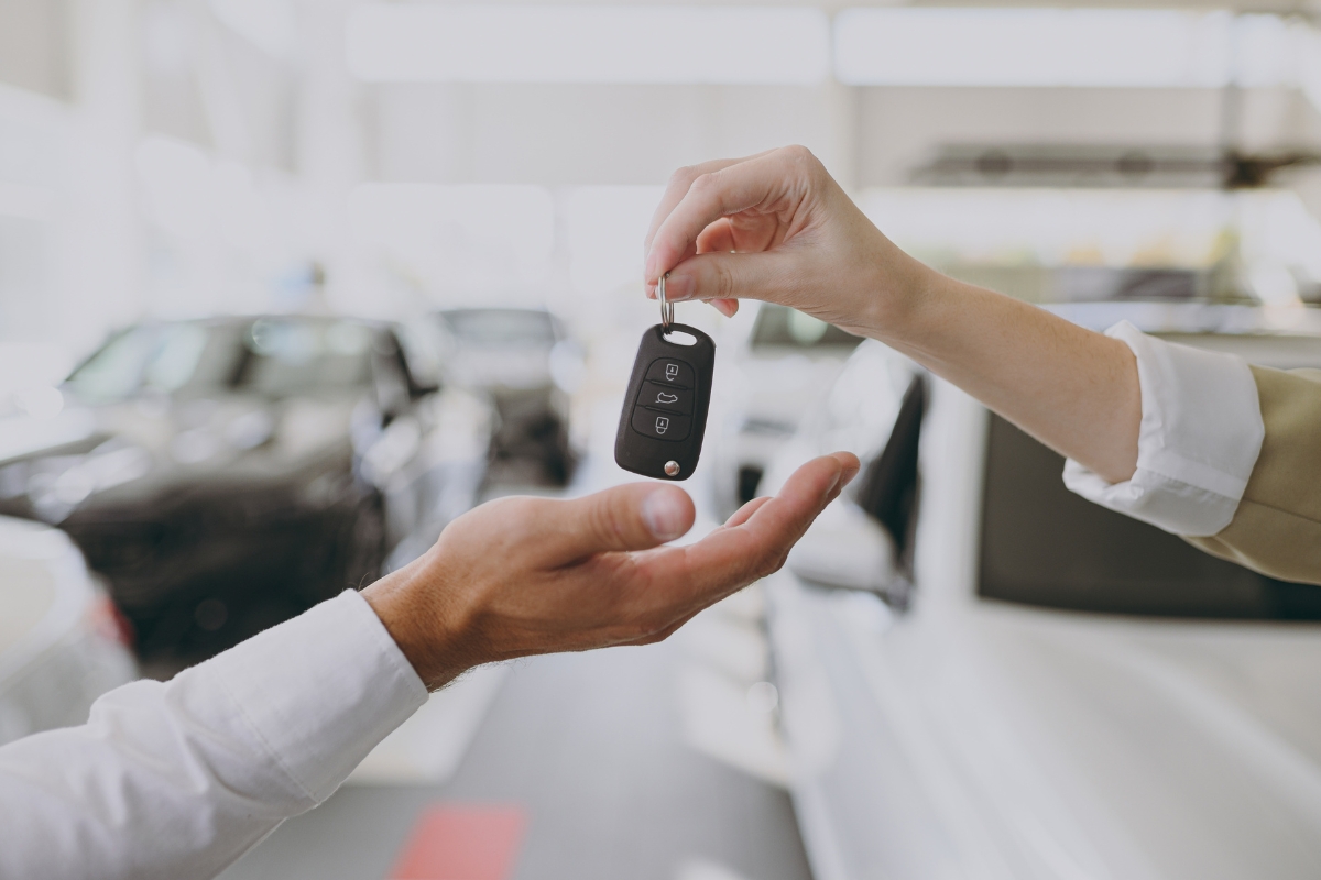 prikaz osobe koja predaje ključ od automobila drugoj osobi u auto kući